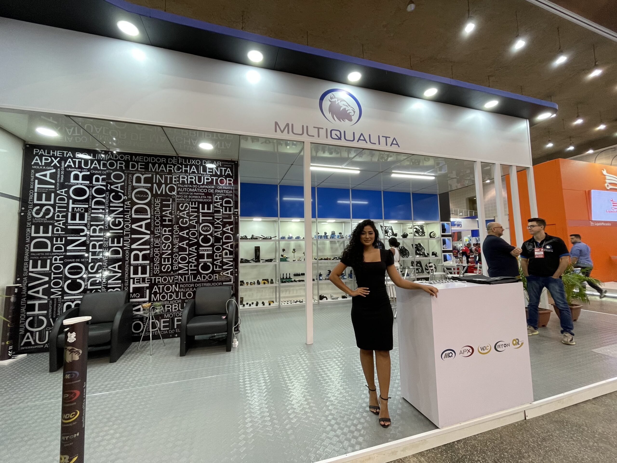 Interior do stand, com a parede tipográfica e o balcão de atendimento