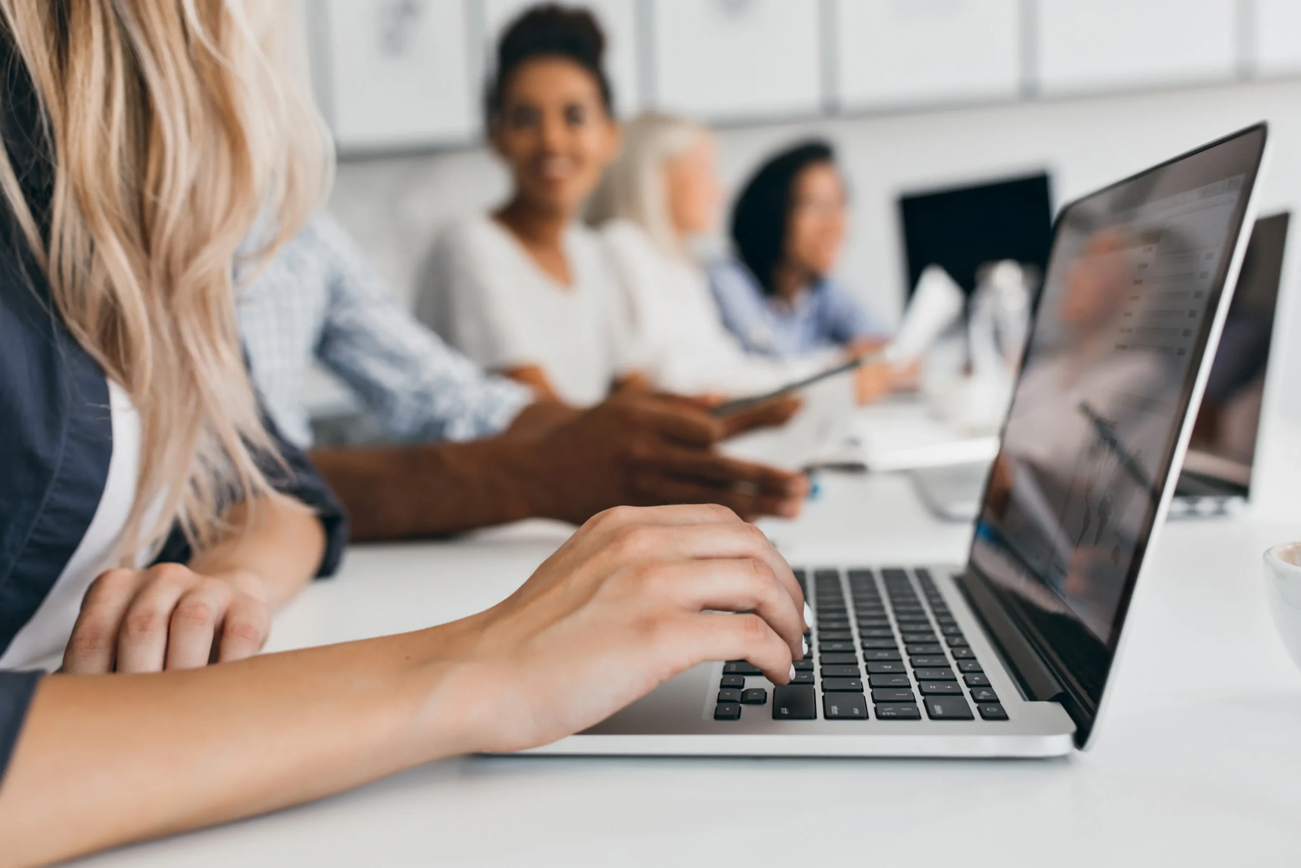 Equipe em sala de reunião, com o treinamento aberto no notebook